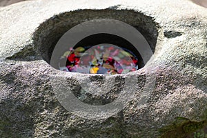 Japanese flower stone basin with floating pink flowers on water in zen spa at night in Kyoto street