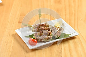 Japanese food aspara bacon-wrapped asparagus rolls in a white tray side view on wooden background