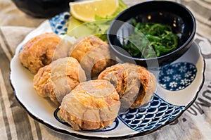 Japanese food: fried chicken karaage with lemon and seaweed salad
