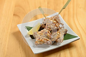 japanese food fried Tebasaki in a white dish isolated on wooden table top view photo
