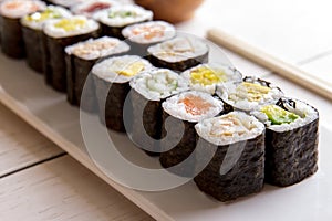 Japanese food mini maki sushi platter on white wooden table
