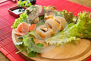 Japanese food restaurant platter set. Hand take roll. Set for two with chopsticks, ginger, soy, wasabi. Sushi at rustic wood backg