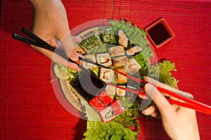 Japanese food restaurant platter set. Hand take roll. Set for two with chopsticks, ginger, soy, wasabi. Sushi at rustic wood backg