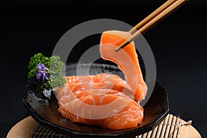 Japanese food, Salmon sashimi with parsley leaf on black plate