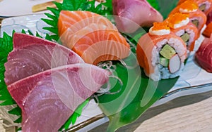 Japanese food set served on white plate. Salmon sushi and sashimi on restaurant table. Fresh raw fish meat sliced and Japan