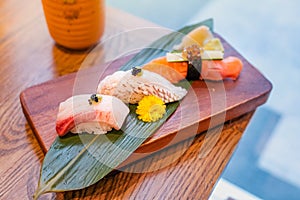 Japanese food, set of sushi put on a rectangular wooden plate and a cup of green tea beside
