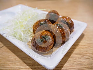 Japanese food Tako Yaki on white plate.