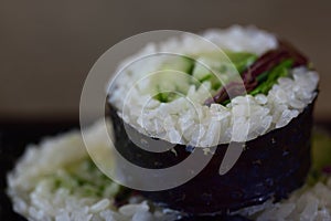 Japanese food with a thick roll futomaki, which is filled with vegetables, rice and algae leaves encased