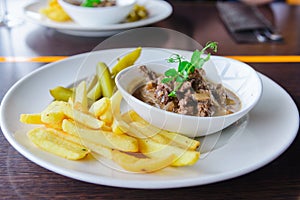 Japanese fried beef fries pickles chili on white plate on a table at restaurant