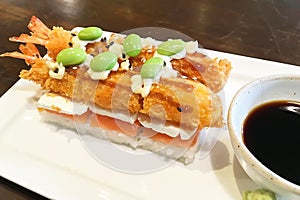 Japanese fusion food creative design with white rice, raw salmon sashimi on top with mayonnaise dressing on crispy fry shrimps and