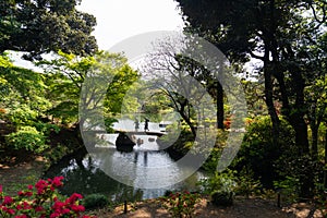 Japanese garden and bridge crossed by two friends