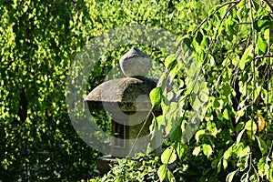 Japanese garden`s stone lantern and fresh leaves, Kyoto Japan.