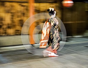 Japanese geisha fast walk during rainy night at Gion District in Kyotom Japan