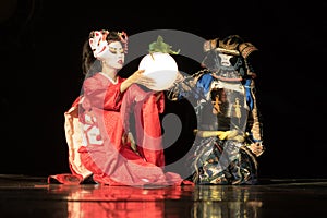 Japanese geisha in traditional kimono and fox mask holding sphere lamp and samurai warrior in armor
