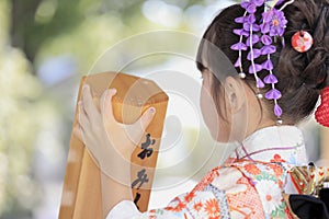 Japanese girl drawing Omikuji in Seven-Five-Three festival cloth