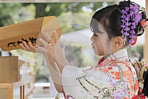 Japanese girl drawing Omikuji in Seven-Five-Three festival cloth