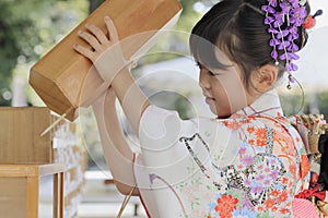 Japanese girl drawing Omikuji in Seven-Five-Three festival cloth