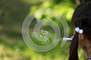 Japanese girl playing with bubble in the green