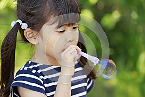 Japanese girl playing with bubble in the green