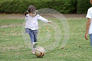 Japanese girl playing with soccer ball