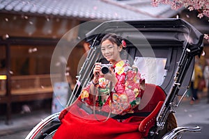 Japanese girl take a photo by her camera and sit on traditional traier