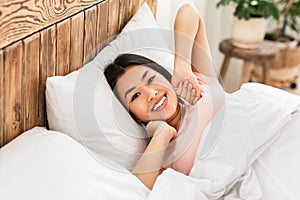 Japanese Girl Waking Up Stretching Hands Lying In Bed Indoor