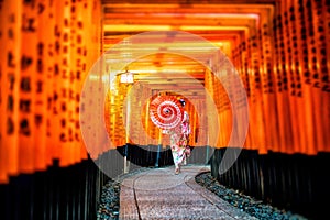 Japanese girl in Yukata with red umbrella at Fushimi Inari Shrine photo