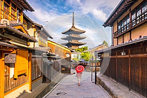 Japanese girl in Yukata with red umbrella in old town Kyoto