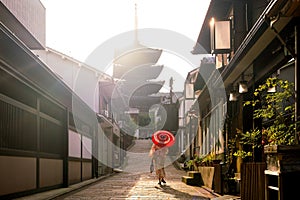 Japanese girl in Yukata with red umbrella in old town Kyoto