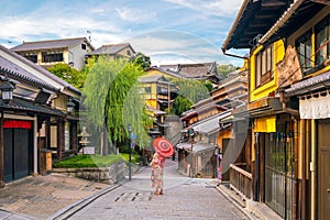 Japanese girl in Yukata with red umbrella in old town Kyoto