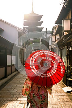 Japanese girl in Yukata with red umbrella in old town Kyoto