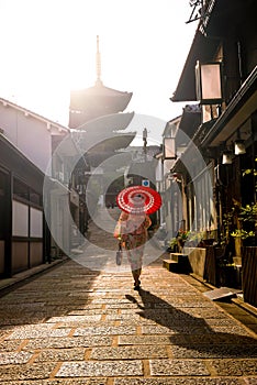 Japanese girl in Yukata with red umbrella in old town Kyoto