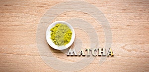Japanese Green powder matcha tea on a platter, on a brown background. Inscription of the wooden letters in English.
