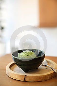 Japanese green tea ice cream with red bean topping on wooden table in coffee shop