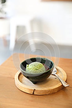 Japanese green tea ice cream with red bean topping on wooden table in coffee shop