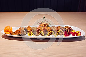 Japanese grilled Unagi Maki roll on white plate dark background