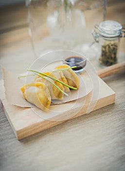 Japanese guiozas with soya sauce on wooden chopping table photo