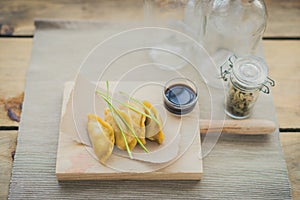 Japanese guiozas with soya sauce on wooden chopping table photo