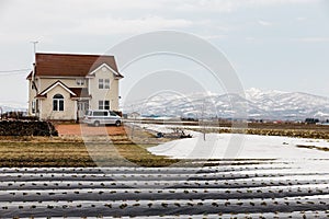 Japanese house with farm and now on the ground with Mount Yotei in the background in winter in Hokkaido, Japan