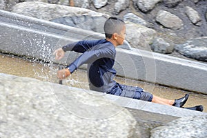 Japanese junior high school student playing in the river with water slide