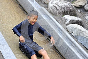 Japanese junior high school student playing in the river with water slide