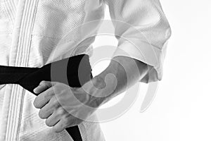 Japanese karate and sports concept. Guy poses in white kimono with black belt, close up.