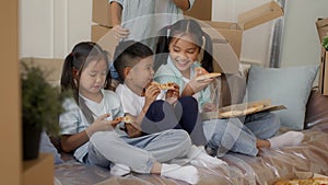 Japanese Kids Eating Pizza While Mother Packing Moving Boxes Indoor