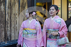 KYOTO, JAPAN - NOVEMBER, 8, 2019: Japanese Ladies Posing in Geisha Kimono At One of the Kyoto Streets, Japan