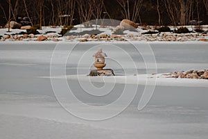Japanese lantern statue frozen in the middle of a pond