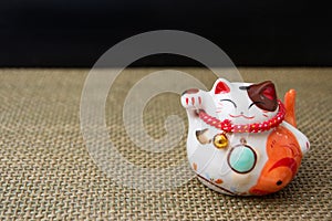 Japanese lucky cat maneki-neko on wattled fabric