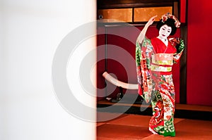 Japanese Maiko, Geisha in red kimono performs dancing show with