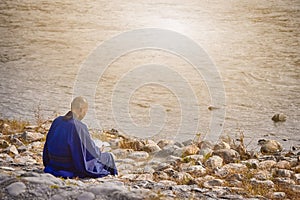 Japanese Male Monk in Blue Robe Reading Book on River Bank