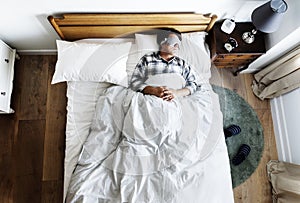 Japanese man sleeping on bed with eye mask photo