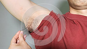 Japanese man touching armpit hair